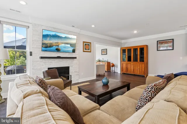 a living room with furniture kitchen view and a fireplace
