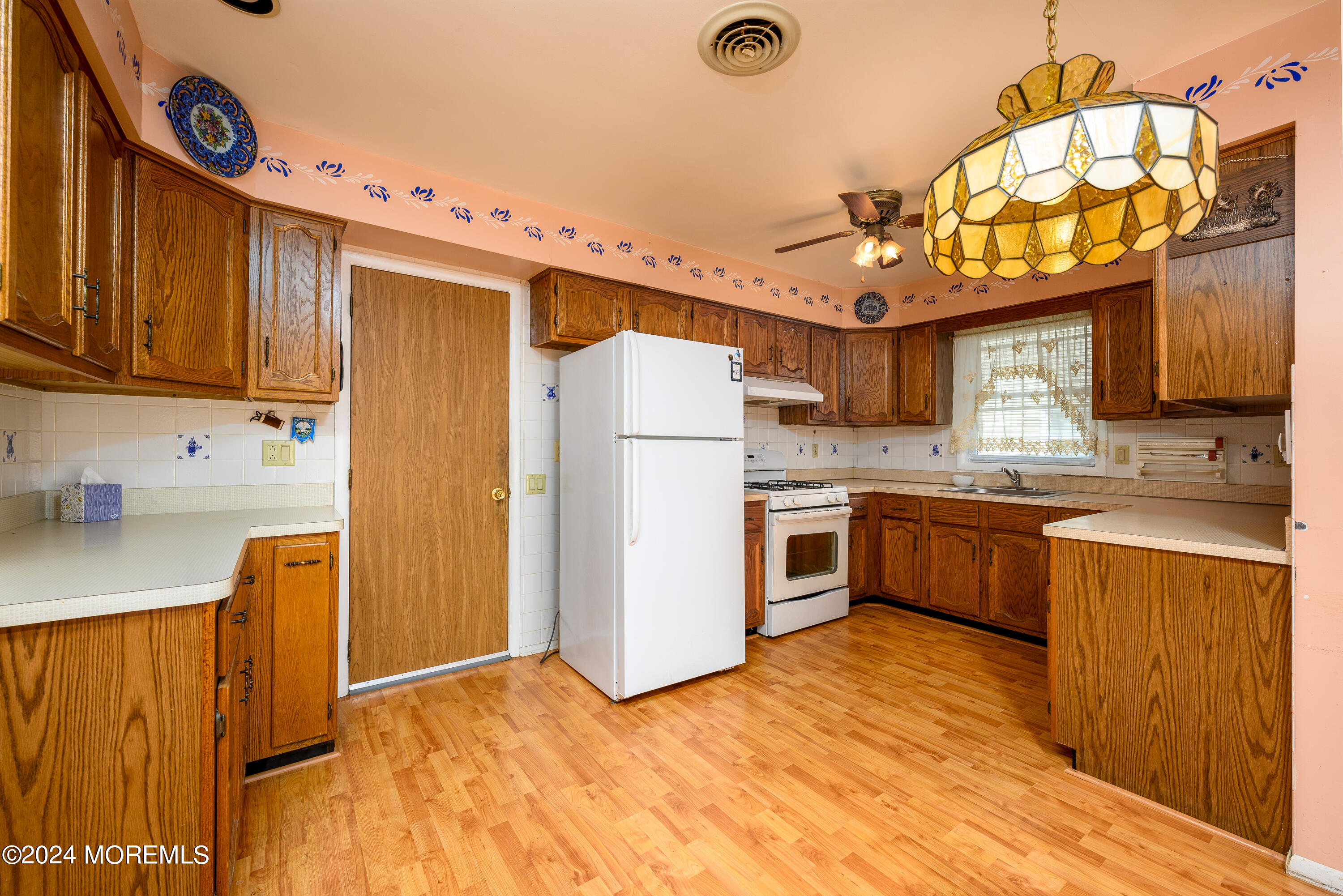 56 Auburn Road Toms River, NJ 08757 - Photo 12 of 28 a kitchen with a refrigerator a stove top oven a sink and dishwasher with wooden floor