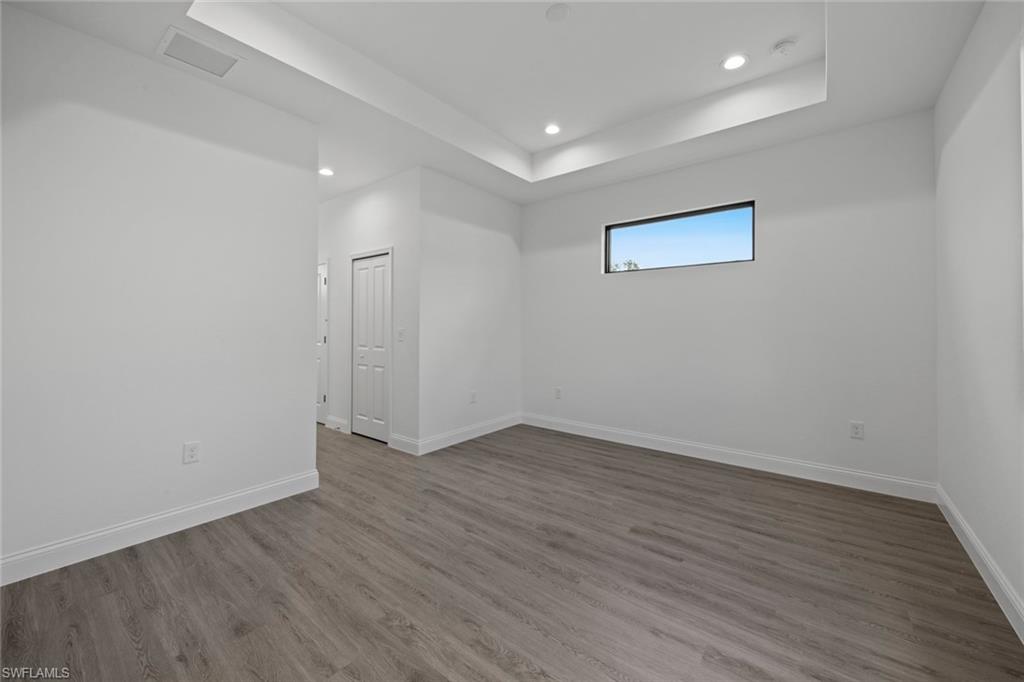 369 Ranier Avenue Lehigh Acres, FL 33974 - Photo 11 of 22 an empty room with wooden floor and windows