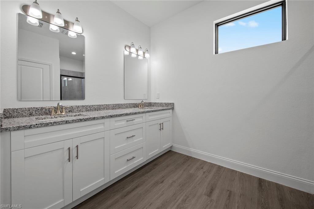 369 Ranier Avenue Lehigh Acres, FL 33974 - Photo 14 of 22 a bathroom with a granite countertop sink and a mirror
