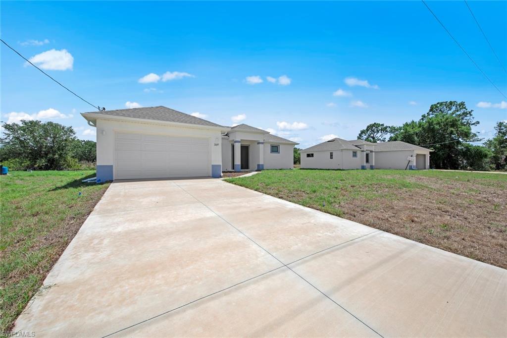 369 Ranier Avenue Lehigh Acres, FL 33974 - Photo 2 of 22 a view of a house with a yard