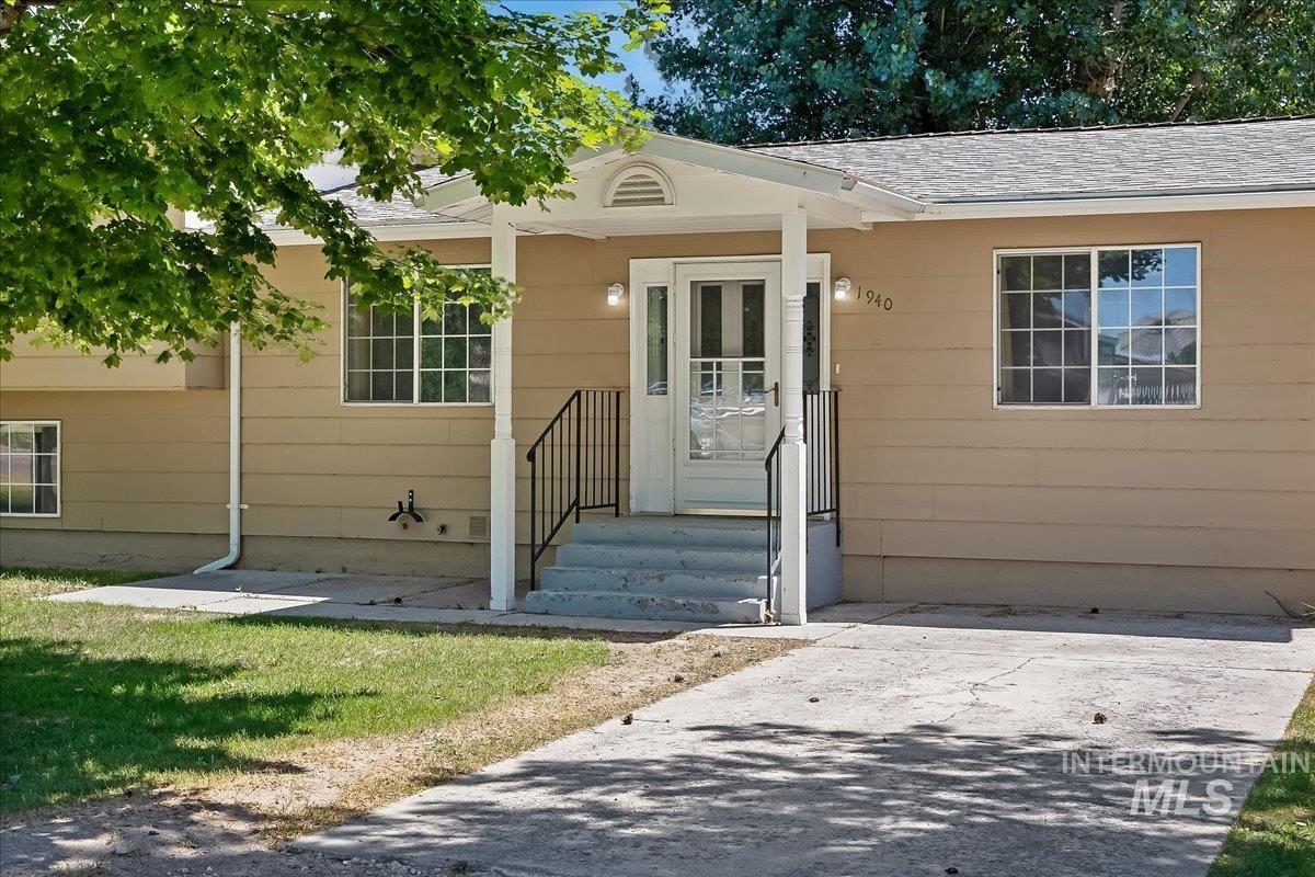 1940 Q Street Heyburn, ID 83336 - Photo 2 of 30 Ranch-style exterior with tan siding and a covered front porch featuring white columns and black railings