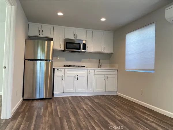 a kitchen with white cabinets and stainless steel appliances