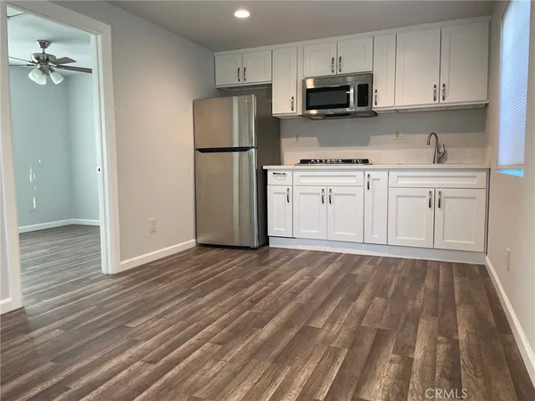 a kitchen with white cabinets and stainless steel appliances