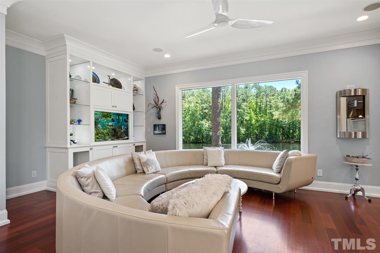 1209 Graedon Drive Raleigh, NC 27603 - Photo 12 of 30 Revel in the views of the pond with illuminated fountain, fireplace, built-in fish tank and pool.