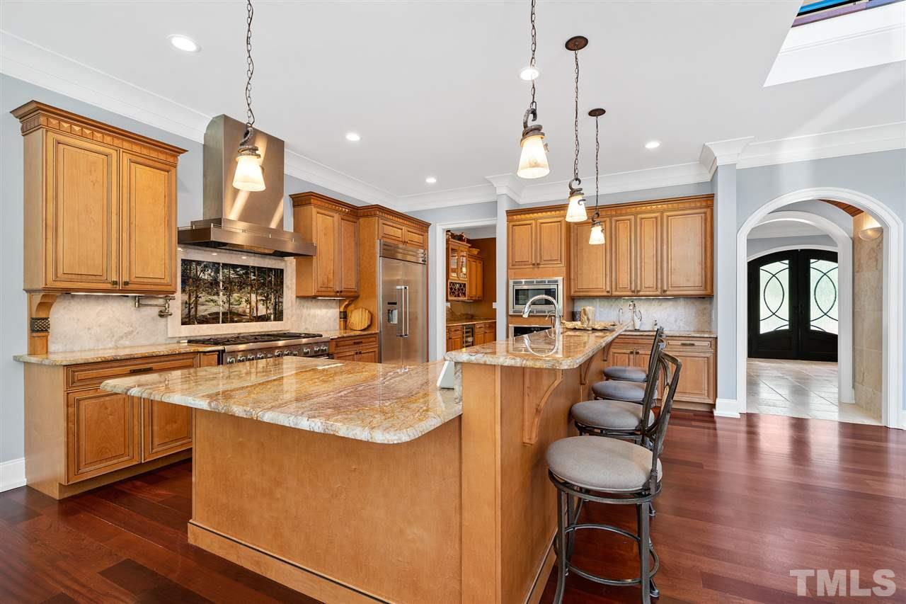 1209 Graedon Drive Raleigh, NC 27603 - Photo 9 of 30 Beautiful LED backlit mural, steam oven, professional stove and griddle, touch faucets, custom cabinetry, and imported Brazilian granite counter tops.