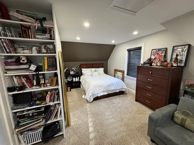 a bedroom with a bed and a flat tv screen on dresser