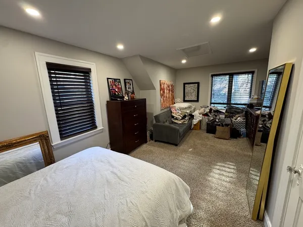 a bedroom with a bed and a flat tv screen on dresser