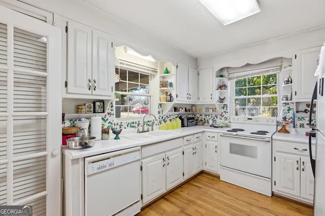 a kitchen with white cabinets and white appliances