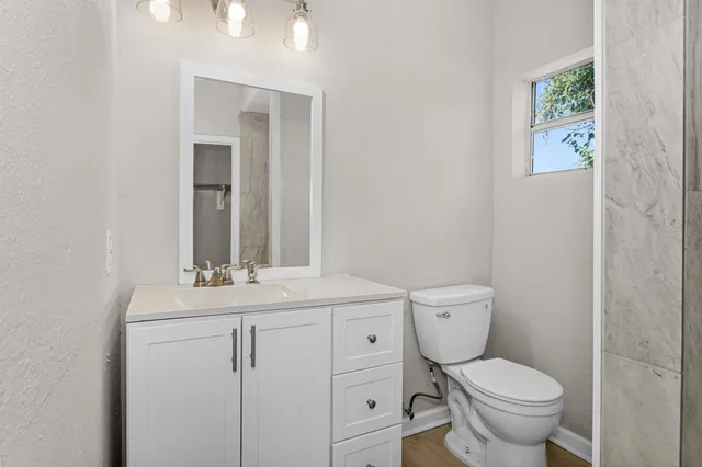 a bathroom with a toilet sink and mirror
