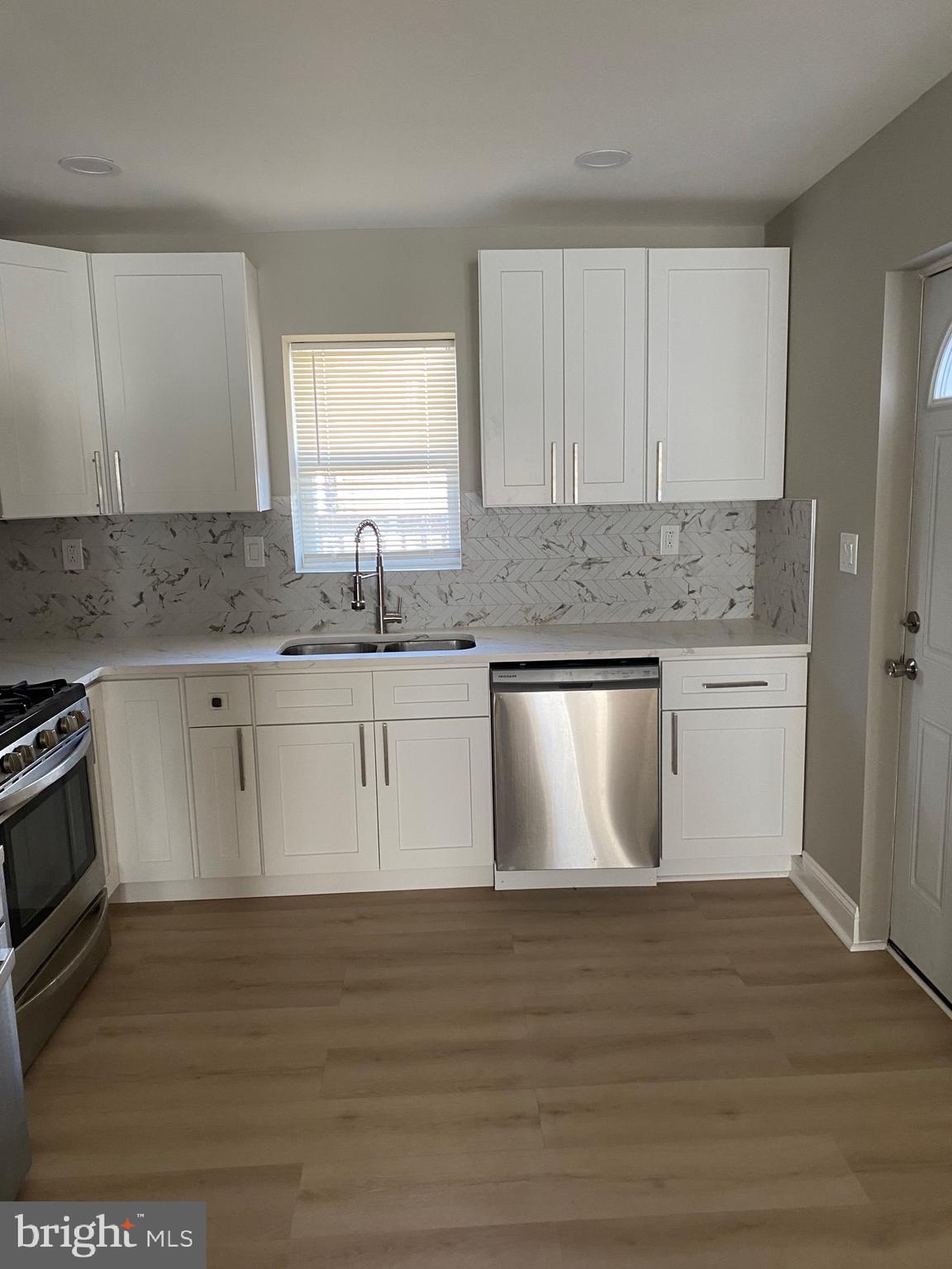 6445 Garman Street Philadelphia, PA 19142 - Photo 6 of 56 a kitchen with stainless steel appliances granite countertop a stove a sink and white cabinets