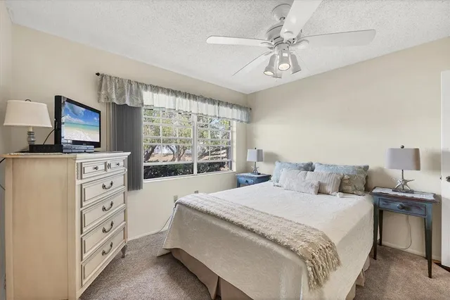 a large bedroom with a bed and a flat tv screen on dresser