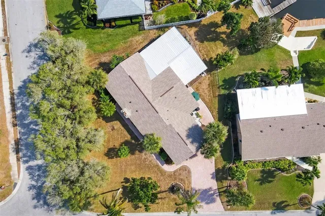 an aerial view of a house with a yard and a large tree