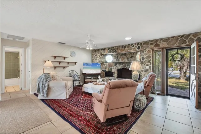 a living room with furniture a fireplace and a chandelier
