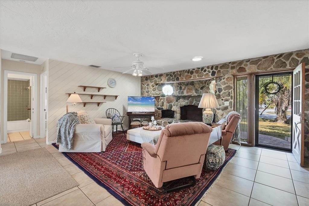 4419 Mangrove Point Road Bradenton, FL 34210 - Photo 5 of 40 a living room with furniture a fireplace and a chandelier