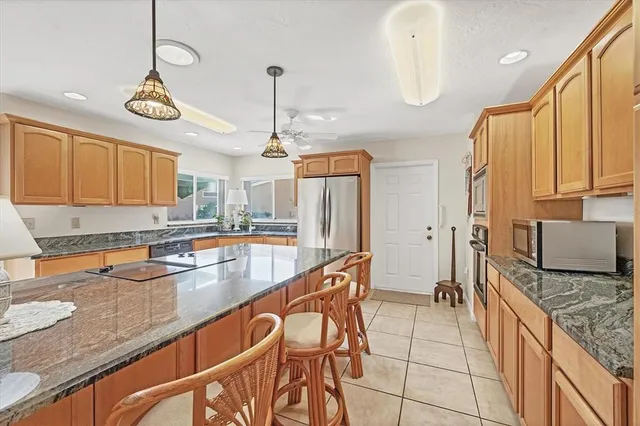 a kitchen with stainless steel appliances granite countertop a sink a stove and a wooden floors