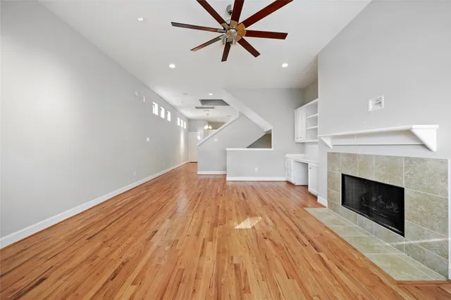 a view of empty room with wooden floor and fireplace