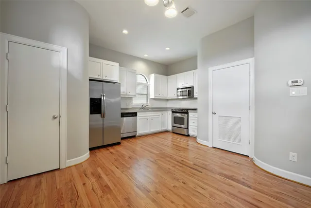 a kitchen with wooden floors and white appliances