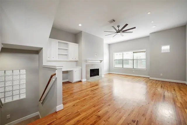 wooden floor fireplace and windows in an empty room