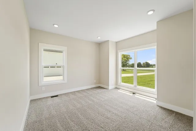 an empty room with a window and a kitchen