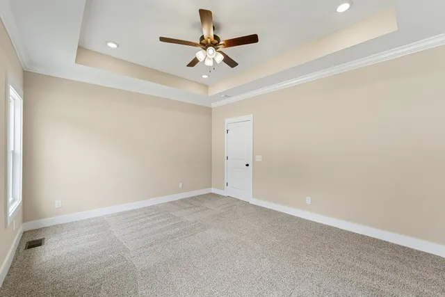 an empty room with a ceiling fan and a window