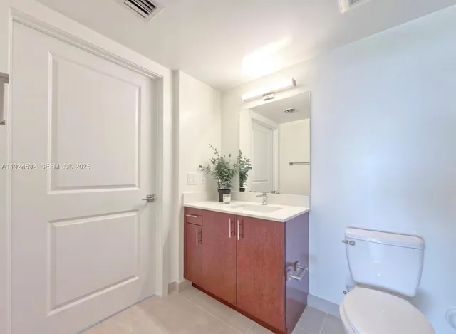 a bathroom with a toilet a sink and mirror