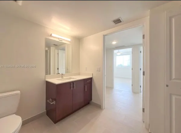 a view of bathroom with a toilet sink and mirror