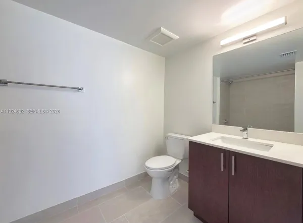 a bathroom with a sink a toilet a mirror and vanity