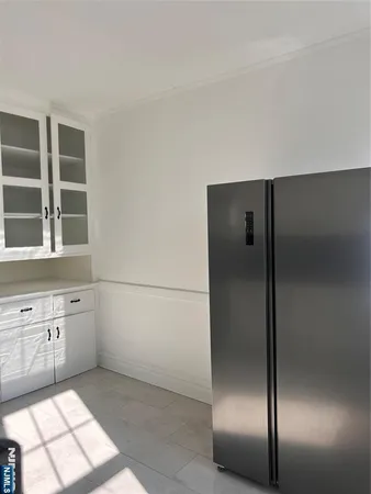 a view of a refrigerator in kitchen and wooden cabinets