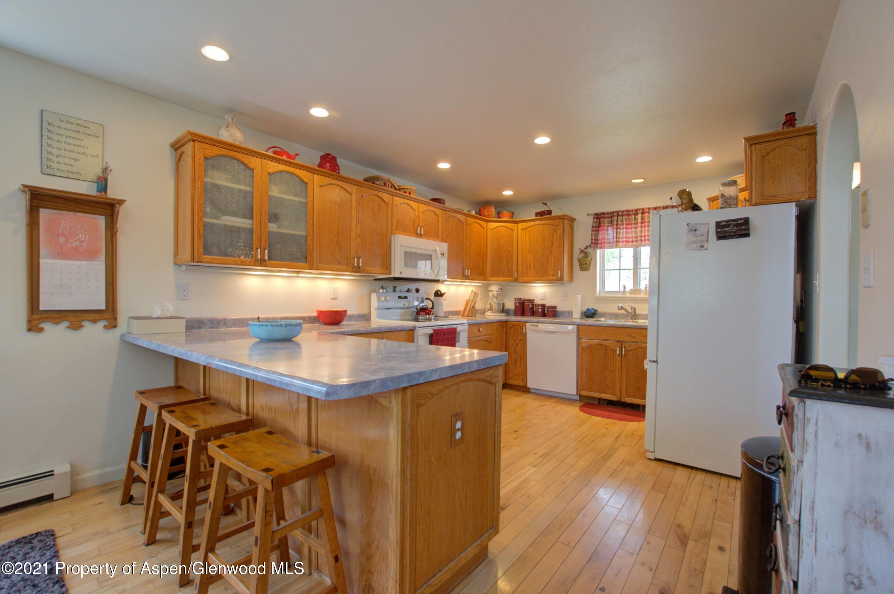 1554 East 12th Street Rifle, CO 81650 - Photo 9 of 31 a kitchen with kitchen island stainless steel appliances a sink a stove a refrigerator and cabinets