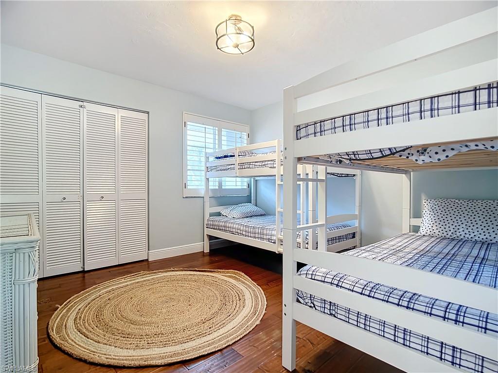 2860 Citrus Lake Drive, Unit R202 Naples, FL 34109 - Photo 24 of 50 a bedroom with a bed and a chandelier