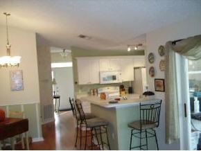 663 Southeast Raleigh Palm Bay, FL 32909 - Photo 3 of 7 a kitchen with a dining table chairs and refrigerator