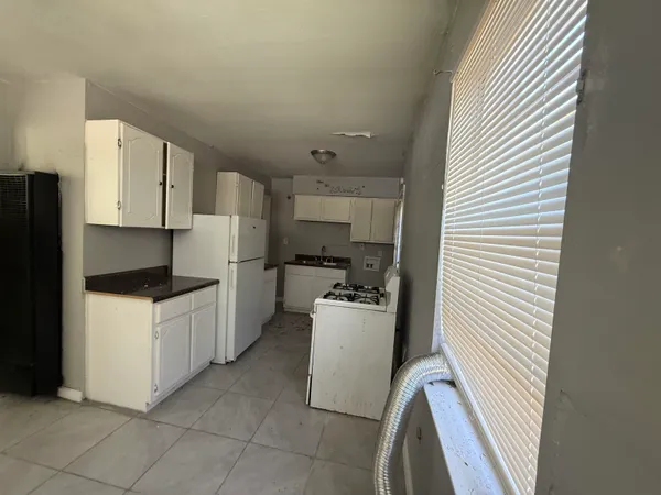 a kitchen with a refrigerator and white cabinets