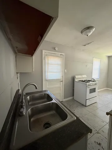 a kitchen with a sink and a stove top oven
