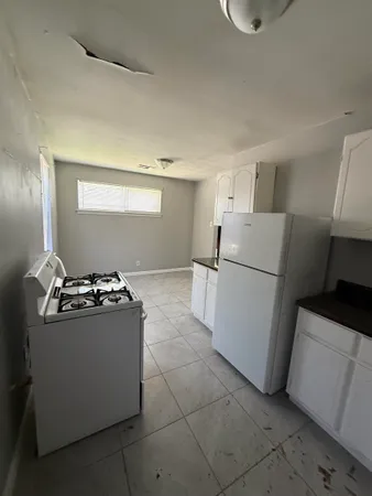 a kitchen with a stove top oven and refrigerator