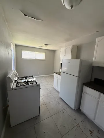 a kitchen with a stove top oven and refrigerator