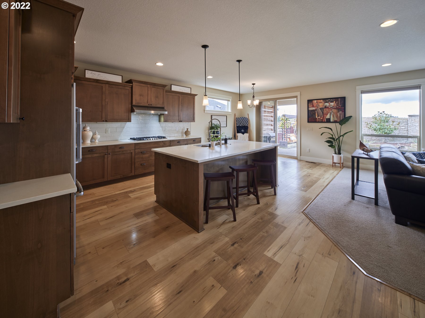 1837 South 46th Place Ridgefield, WA 98642 - Photo 3 of 32 a large kitchen with kitchen island a sink a stove a dining table and chairs