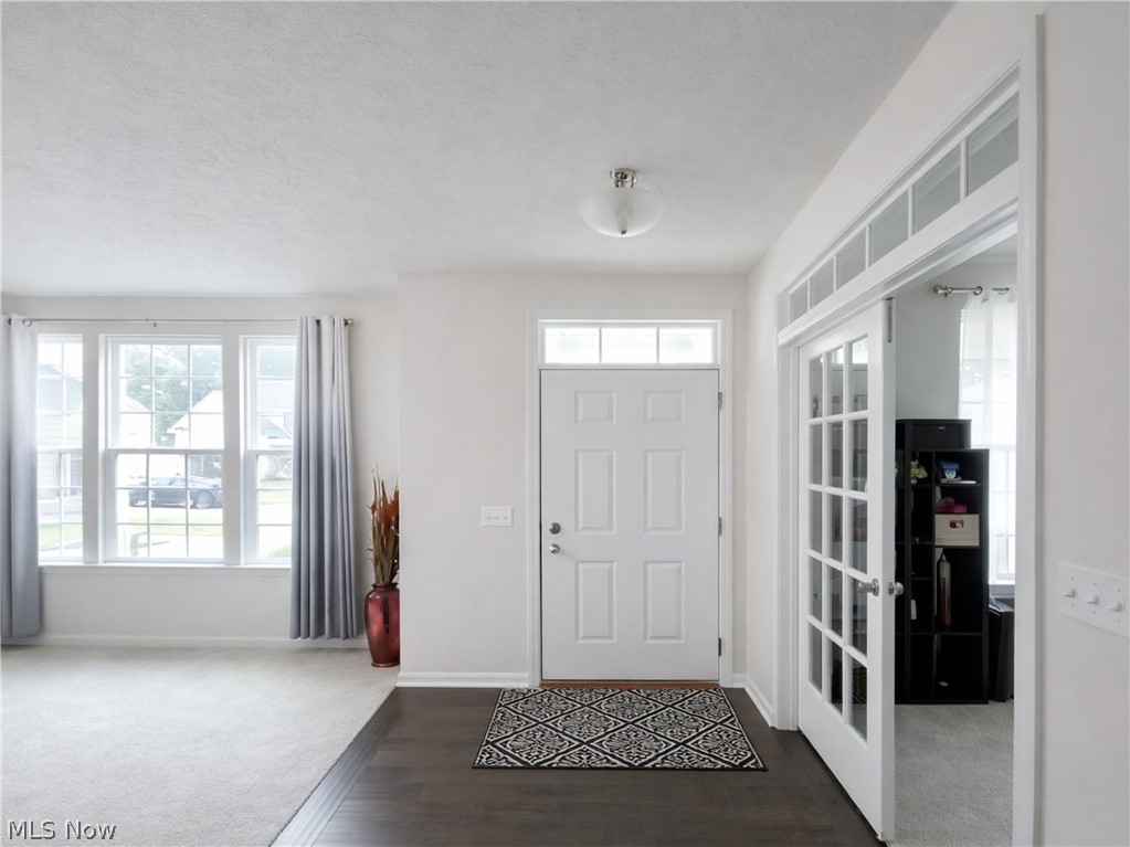 4509 Millbrook Way Akron, OH 44321 - Photo 3 of 27 Entryway featuring a paneled door with transom window, dark wood-finish flooring, and French doors with a transom
