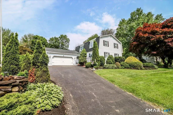 a view of a house with a yard and large tree