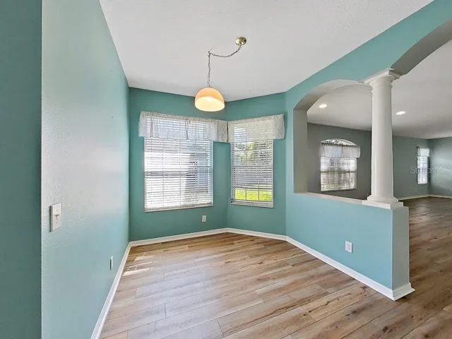 a view of an empty room with wooden floor