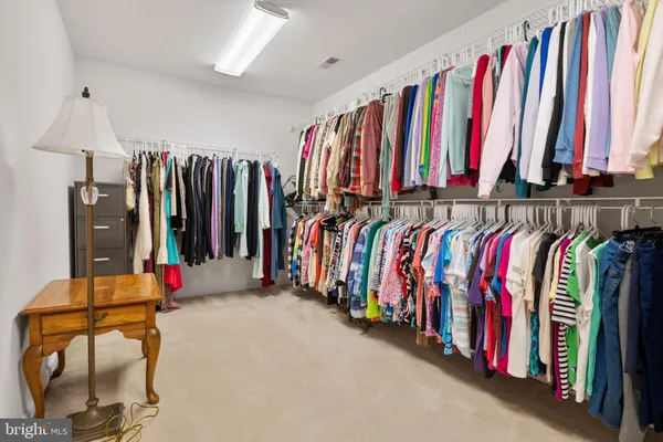 a view of walk in closet with clothes