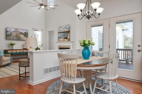 a view of a dining room with furniture a chandelier and wooden floor