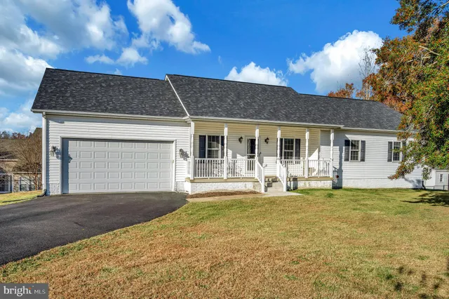 a front view of a house with a garden and yard