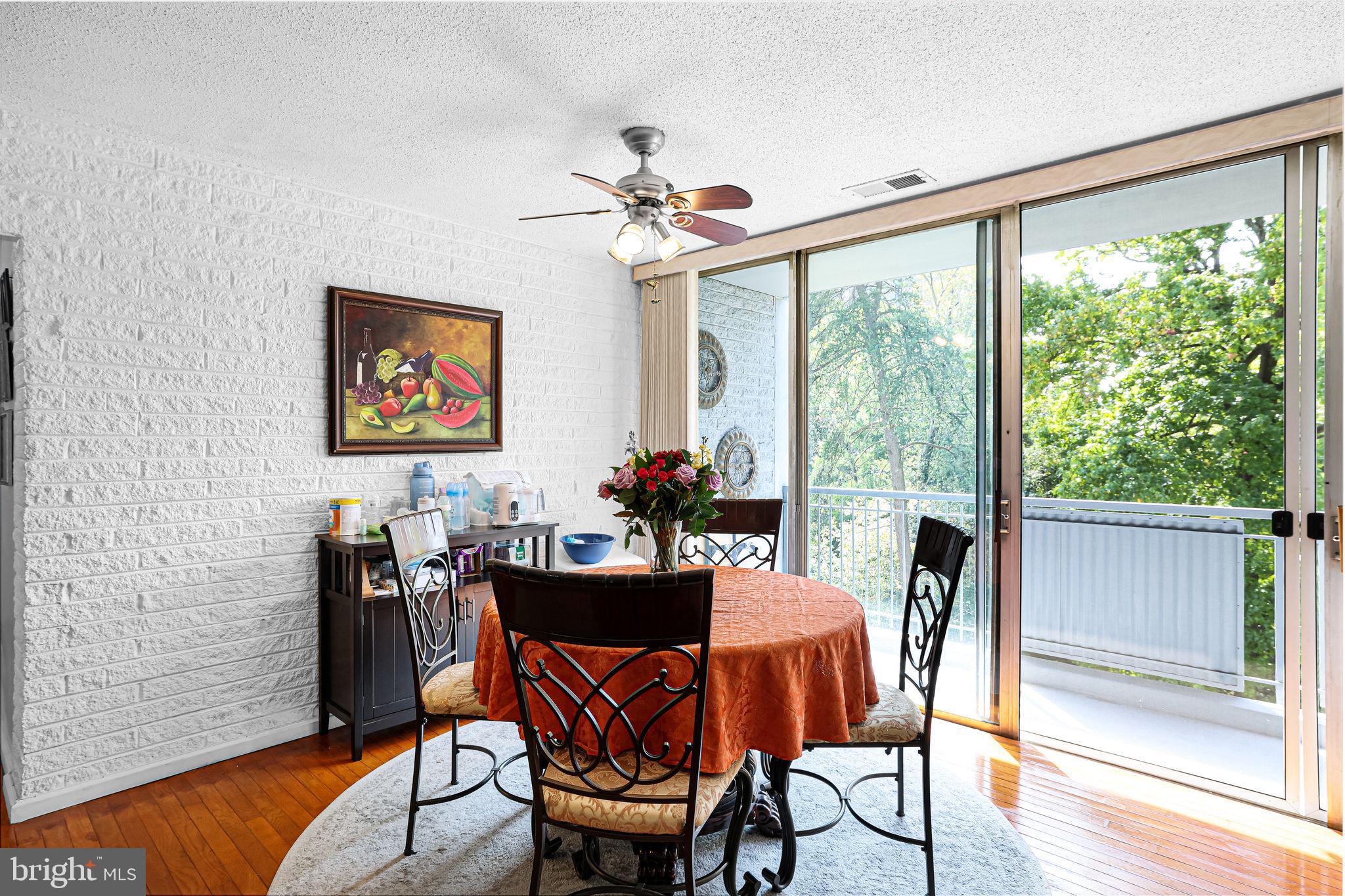 1828 Metzerott Road, Unit 202 Hyattsville, MD 20783 - Photo 3 of 18 a dining room with furniture a large window and wooden floor