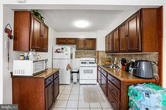 a kitchen with stainless steel appliances granite countertop a refrigerator sink and stove
