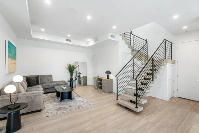 a large kitchen with kitchen island a large window a sink and wooden floor