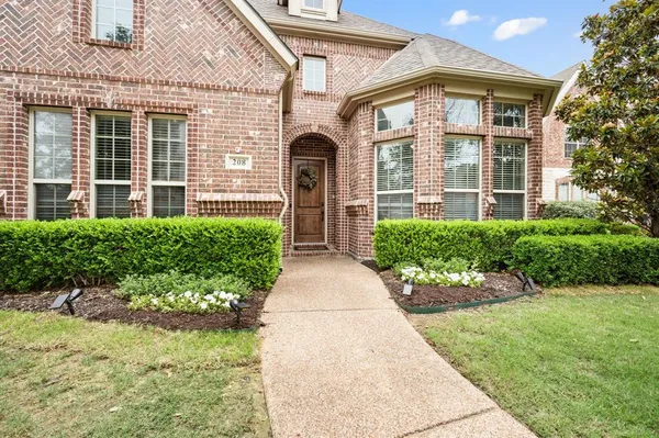 front view of a brick house with a yard