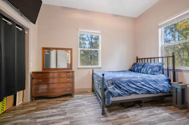 a kitchen with stainless steel appliances granite countertop a refrigerator a stove oven and white cabinets with wooden floors