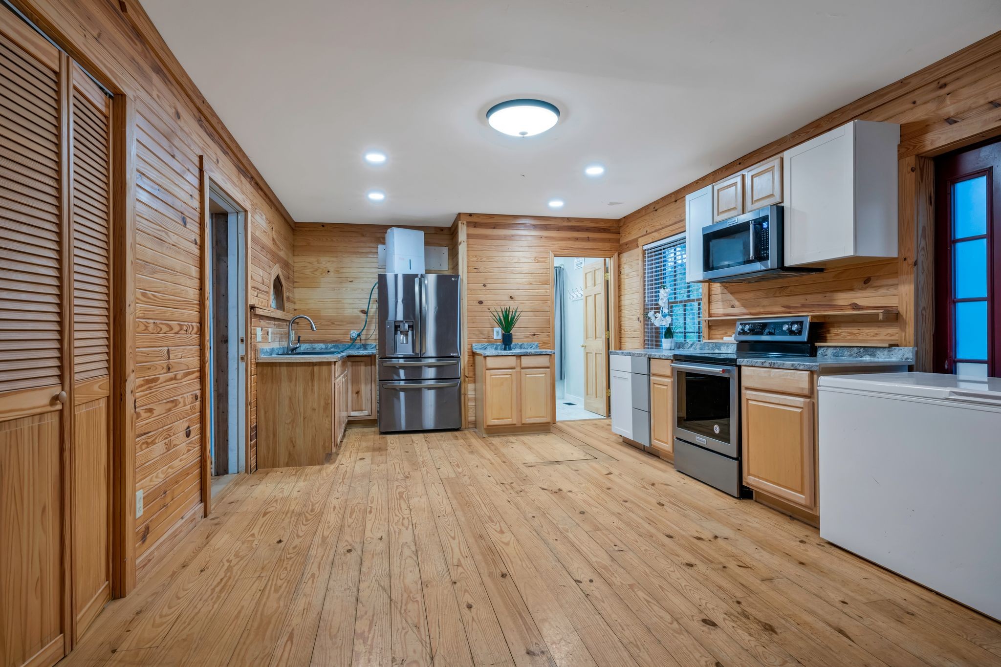 399 Coaling Road Charlotte, TN 37036 - Photo 40 of 73 a kitchen with stainless steel appliances granite countertop a refrigerator a stove oven and white cabinets with wooden floors