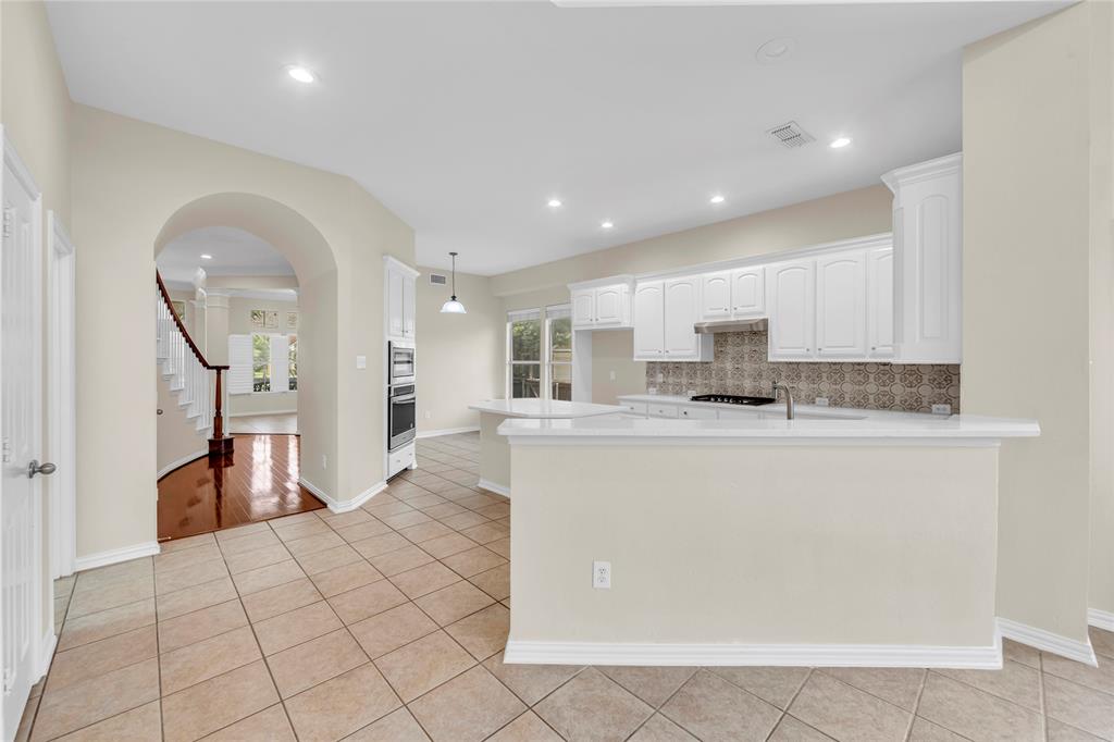 3920 Autumn Lane Bedford, TX 76021 - Photo 14 of 36 Spacious kitchen with white cabinetry, built-in double ovens, and a gas cooktop